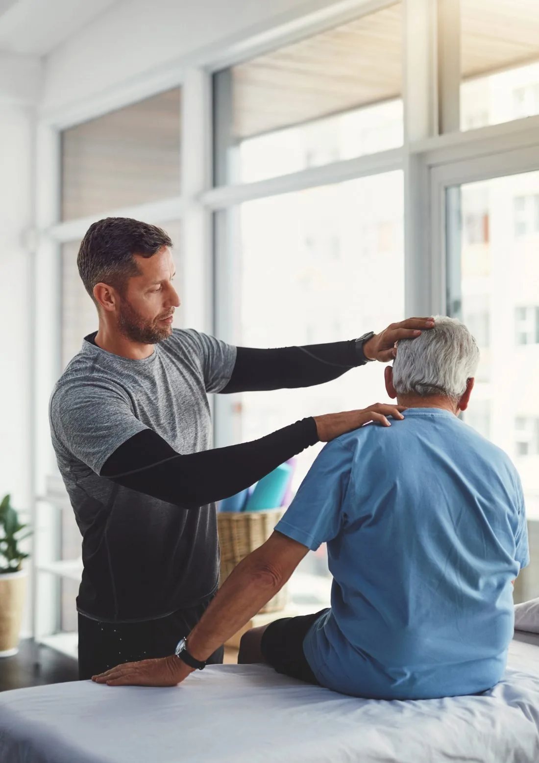 Physiotherapist treating an older patient in a bright clinic