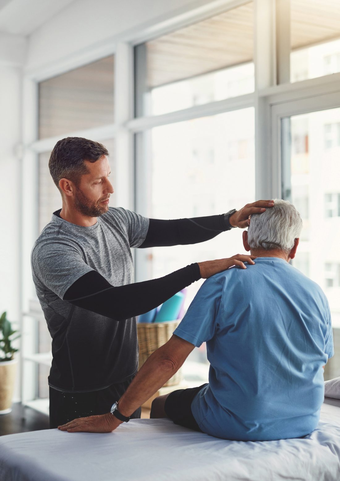 Physiotherapist treating an older patient in a bright clinic