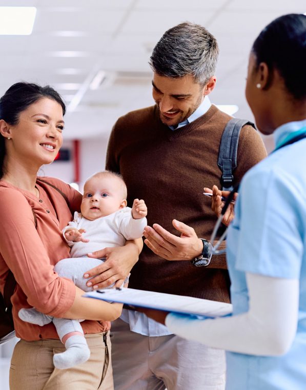 Parents with a baby speaking to a doctor at a medical practice